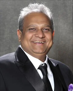 Formal studio portrait of Bhupesh R. Patel in a dark suit and tie